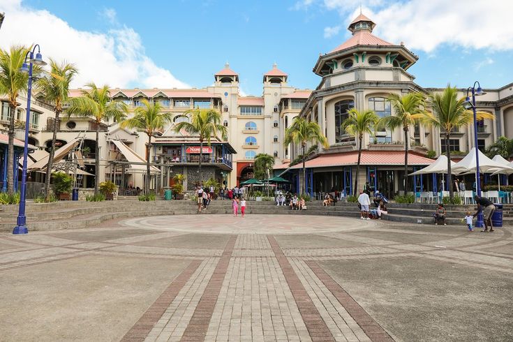 This may contain: people are walking around in front of some buildings