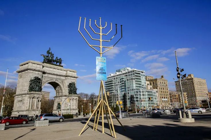 This may contain: a tall metal menorah sitting in the middle of a street