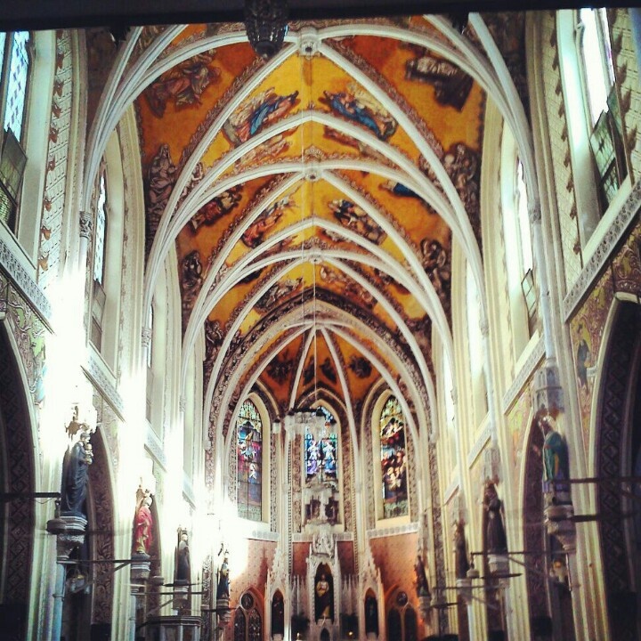This may contain: the inside of a church with high ceilings and stained glass windows
