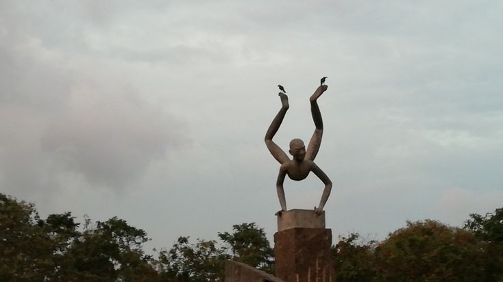 This may contain: there is a statue that has birds on it's back and arms in the air