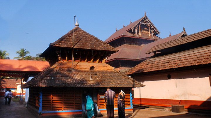 This may contain: two men standing in front of an old building with wooden roofing and tall towers