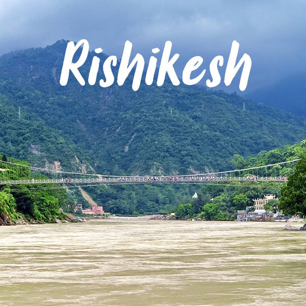 This may contain: a bridge over a river with the words rishikesh in front of it