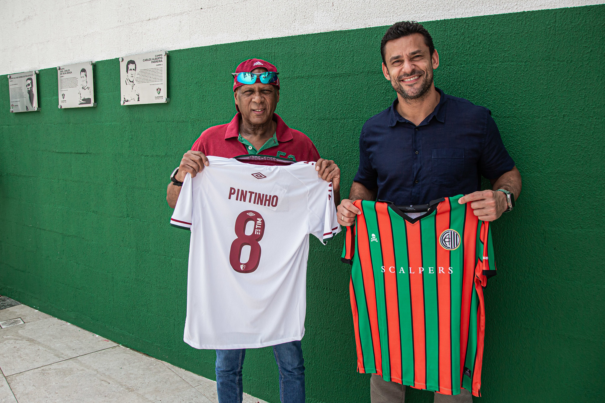 Pintinho poses with Fluminense and Sevilla shirts.