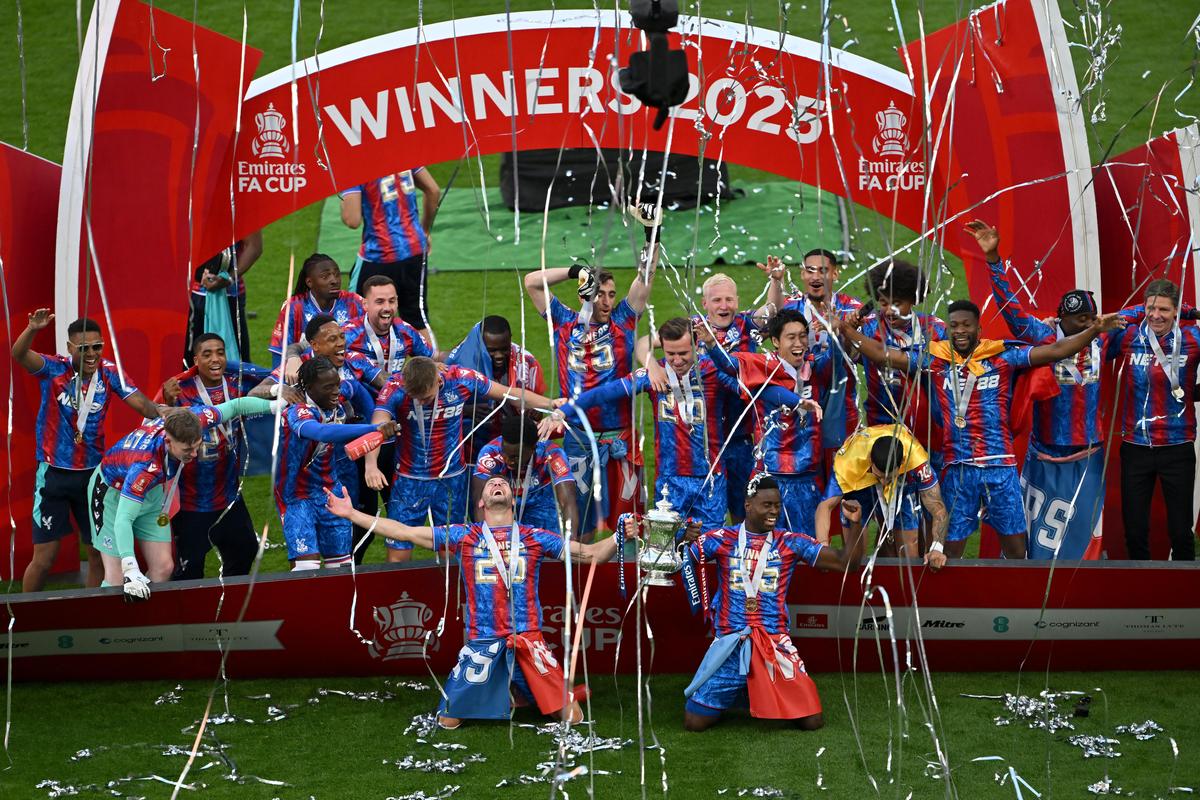 Marc Guehi and Joel Ward of Crystal Palace lift the FA Cup trophy after their team's victory in the FA Cup final against Manchester City.