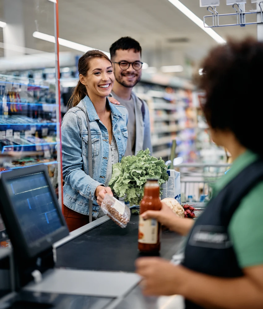 couple chatting with grocery store cashier