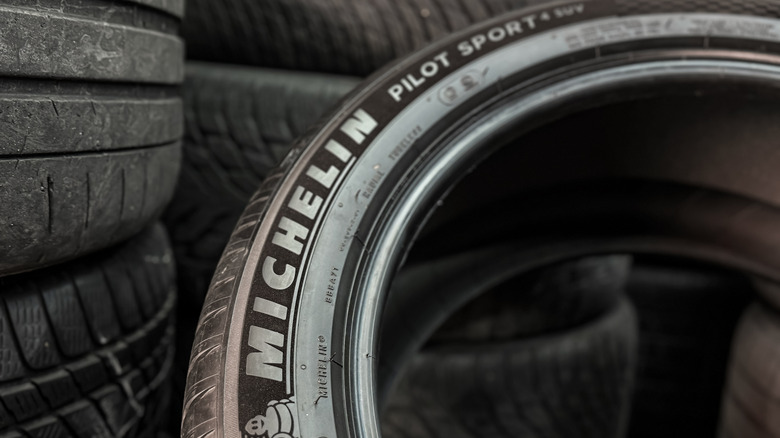 Michelin Pilot Sport 4 tire in front of a stack of tires