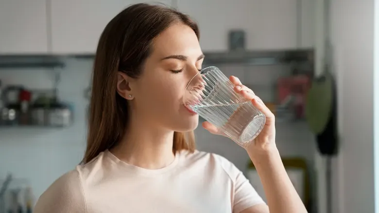 woman drinking water with her eyes closed