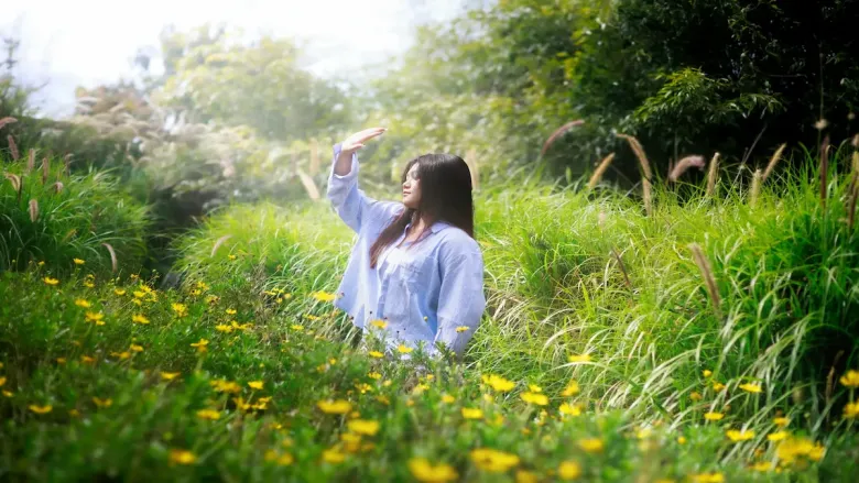 woman in green lush environment having sun exposure