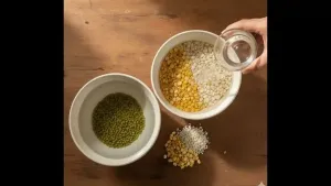 Moong dal (with skin), chana dal, and urad dal being washed thoroughly with clean water and soaked for about 30 minutes.