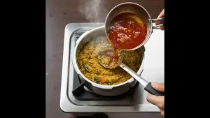 Hot tempering poured into cooked lentils and mixed thoroughly. Lentils simmered on low heat for 2-3 minutes.