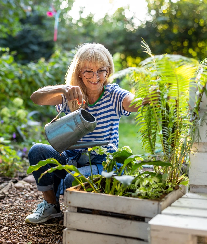 older woman watering plants in garden elderly woman shares things give happy life