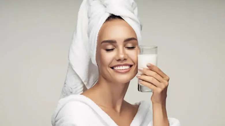 woman holding a glass of milk near her face