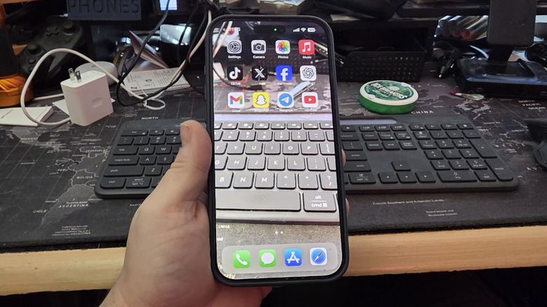 A man holding an iPhone with a transparent wallpaper