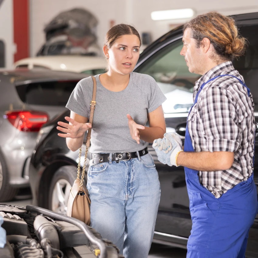 woman talking to mechanic about fixing car has access to resources from living a privileged life
