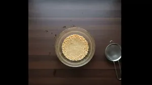 Chana dal being rinsed and soaked in a bowl of water to soften before cooking.