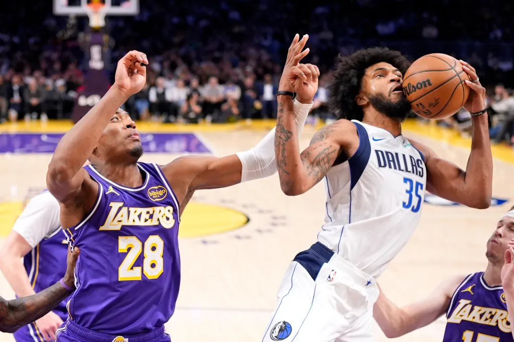 Dallas Mavericks forward Marvin Bagley III holding the ball away from Los Angeles Lakers forward Rui Hachimura.