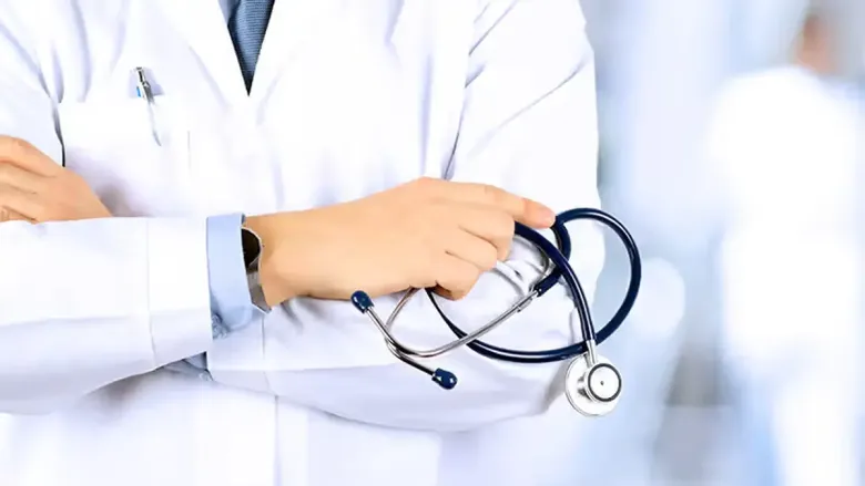 Doctor holding a stethoscope while wearing a white lab coat.