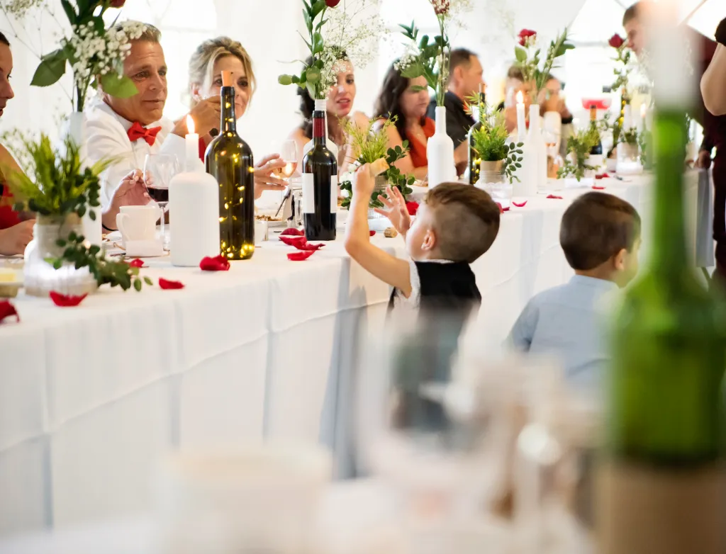 Little boy stealing bread at the table of honour at the wedding reception