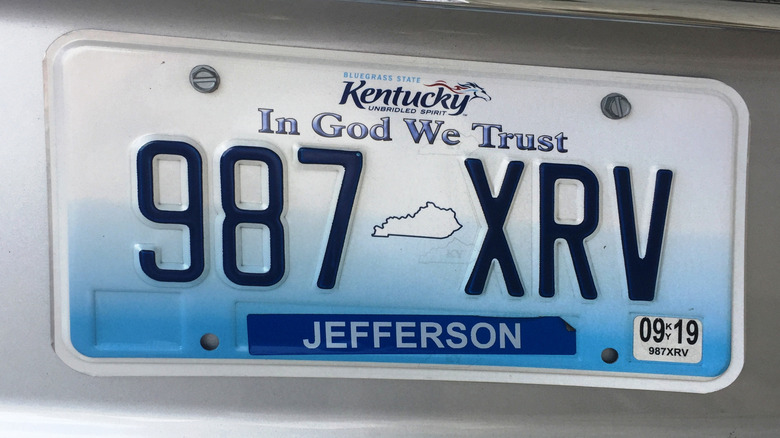 A Kentucky license plate attached to a silver vehicle.