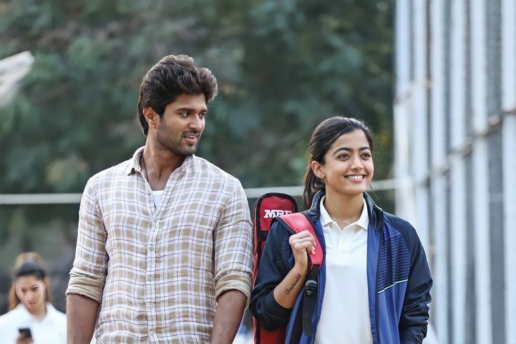 This may contain: a man and woman standing next to each other with backpacks on their shoulders, smiling