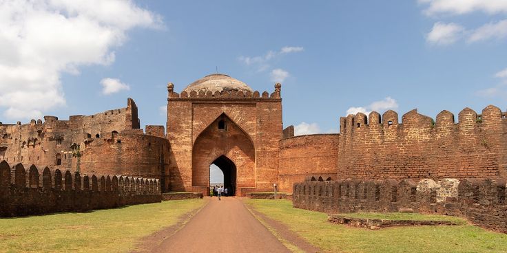 This may contain: the entrance to an old brick castle with a walkway leading up it's side