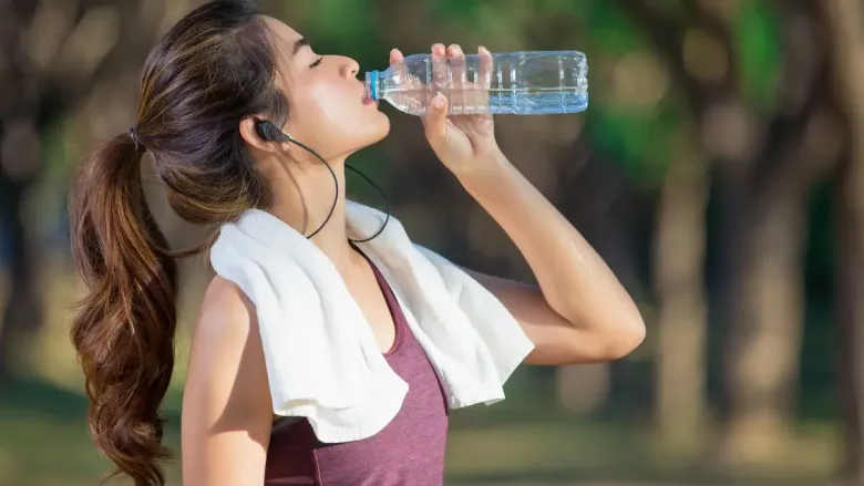 woman drinking water from a bottle