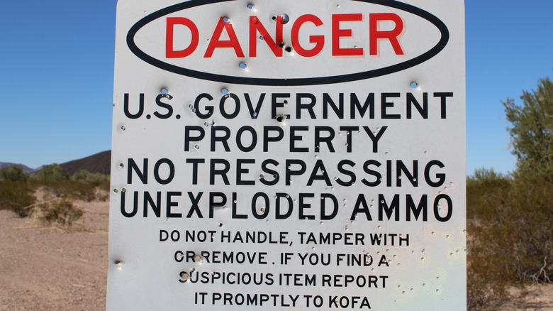 A no-trespassing sign warning of potential unexploded ammo.