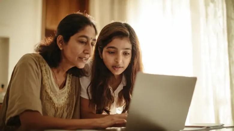 Parent and student checking official CBSE website on laptop to avoid exam paper leak scams