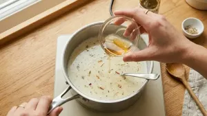 Gently heat the soaked gelatin until it turns liquid, then mix it into the cooled thandai milk.