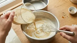 Slowly fold the thandai milk mixture into the whipped cream to keep the mixture light and fluffy.