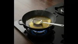 Heat oil in a deep pan on medium flame; Properly heated oil helps the bhallas puff up nicely and prevents them from absorbing excess oil.