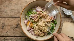 Gradually add a little water at a time to make a thick batter, ensuring it is not too runny since the onions also release moisture.