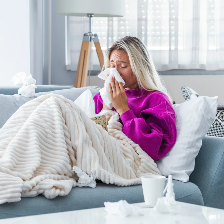 blonde woman home sick on the couch