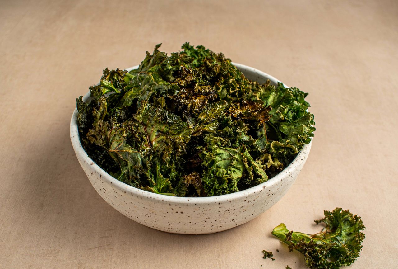 A ceramic bowl filled with kale chips Credit: Christine Ma