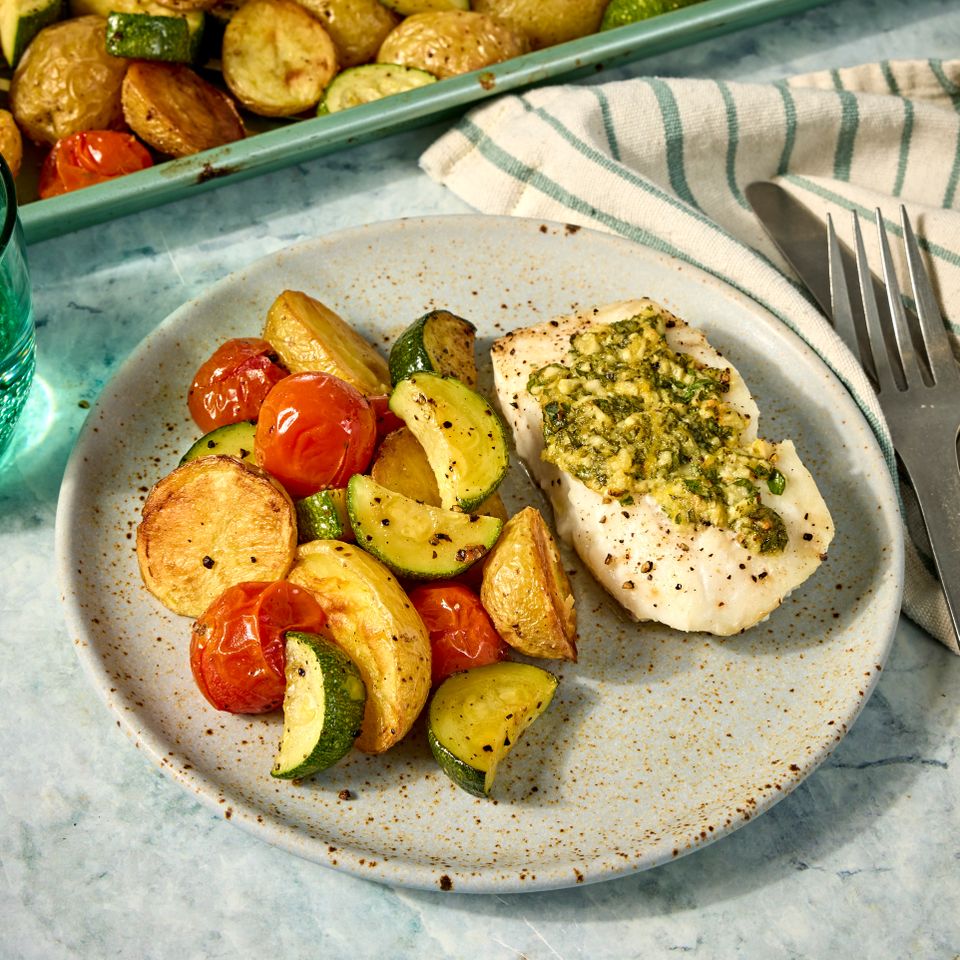 A recipe photo of Sheet-Pan Lemon-Garlic Fish with Zucchini, Cherry Tomatoes & Potatoes. Credit: Photographer: Jen Causey, Food Stylist: Julian Hensarling, Prop Stylist: Claire Spollen.