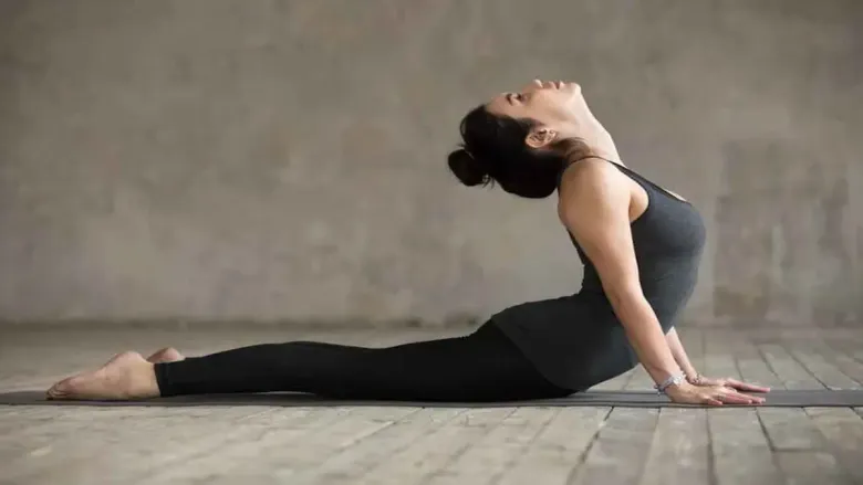 Woman performing Bhujangasana (Cobra Pose) yoga posture with chest lifted and hands on the floor.