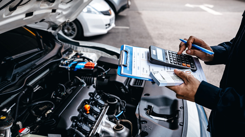 mechanic calculates cost of auto repairs