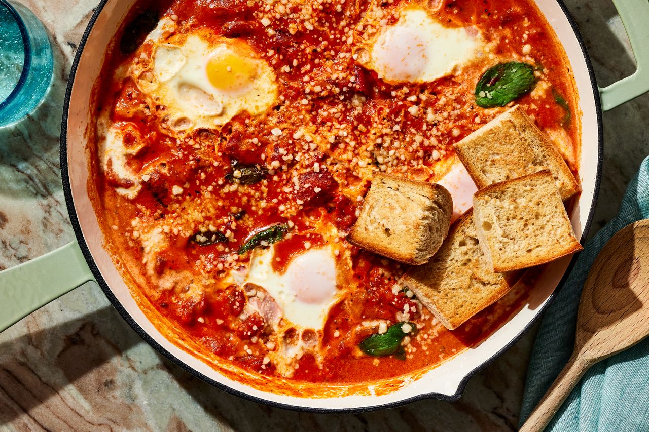 Horizontal image of Vodka Sauce Eggs overhead in a skillet with bread Credit: Photographer: Victor Protasio, Food Stylist: Amanda Stanfield, Prop Stylist: Josh Hoggle