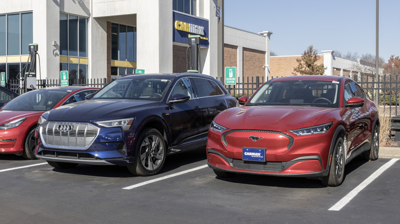 Front view of used Audi and used Mustang Mach-E parked at Car Max dealership.