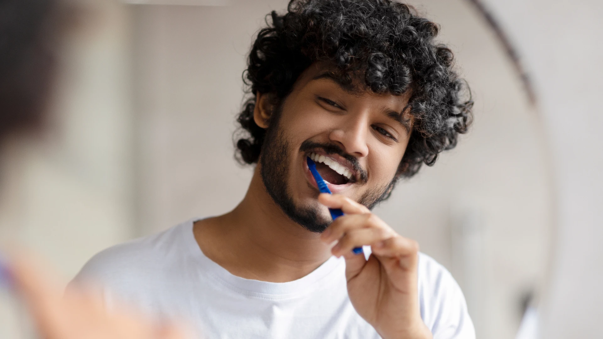 man brushing his teetn reusing the same toothbrush for months