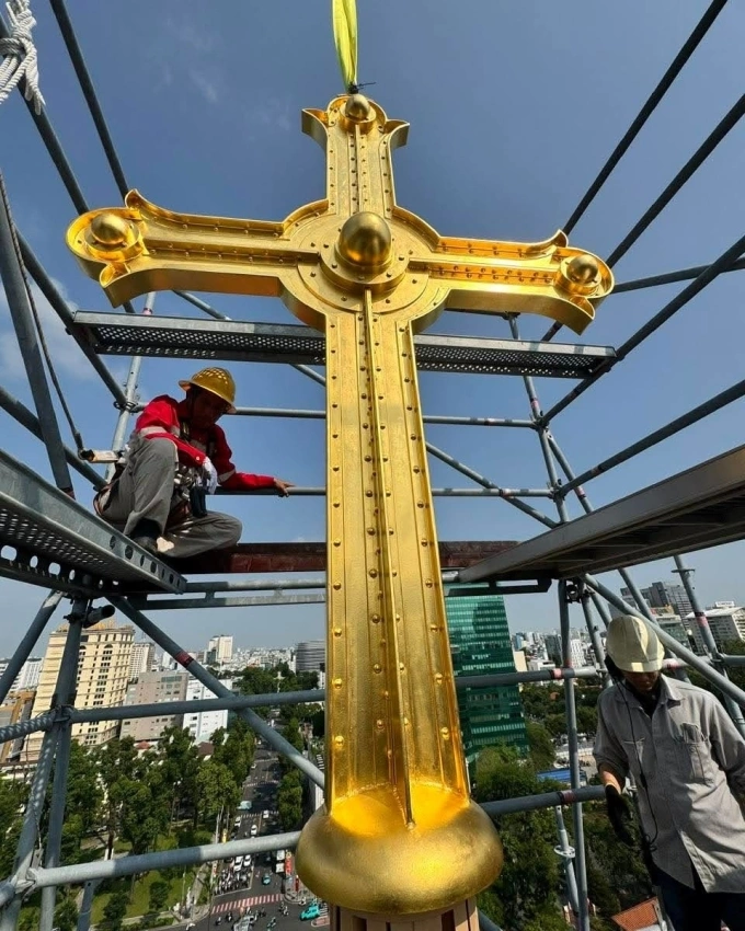 A gold-plated cross is installed atop the Saigon Notre Dame Cathedral on March 19, 2026. Photo by the Archdiocese of Ho Chi Minh City