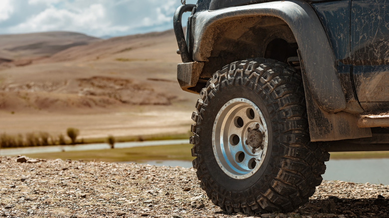 An image of black pickup truck with an off-road tire