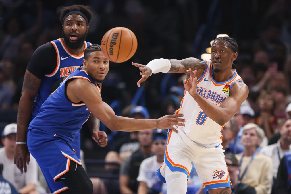 Oklahoma City Thunder guard Jalen Williams (8) passes the ball away from New York Knicks guard Miles McBride, front left, and center Mitchell Robinson, back left, during the first half.