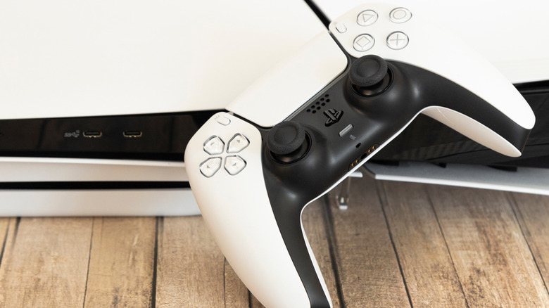 A PS5 controller resting on a PS5 console.