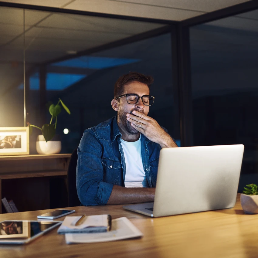 man working after hours to catch up sign of burnout