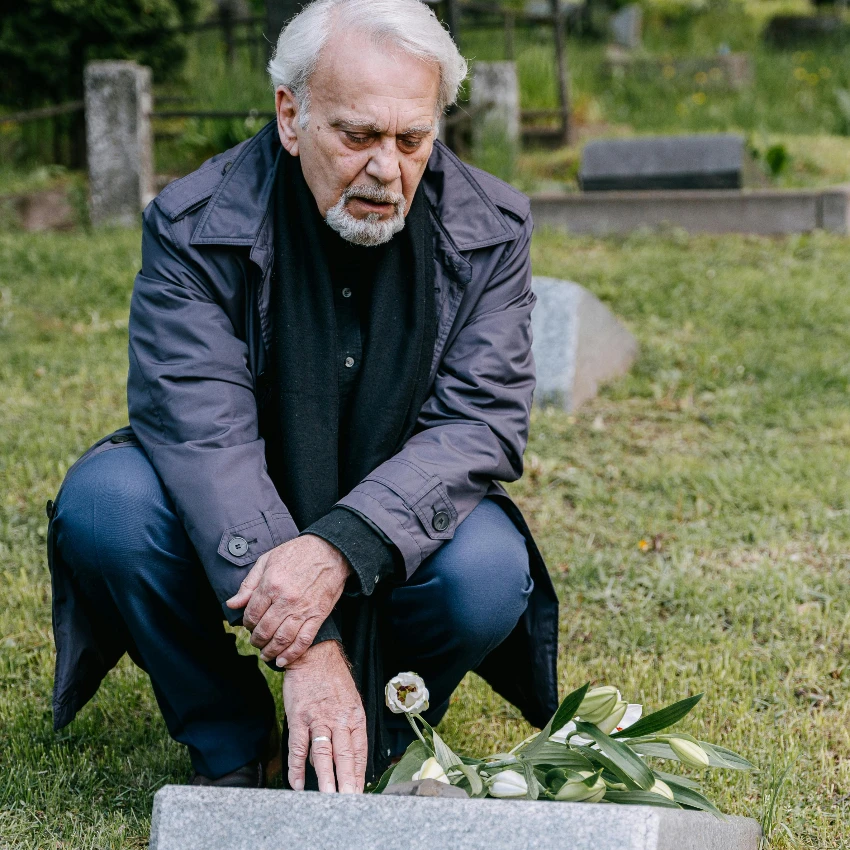 widower visiting his late wife's grave