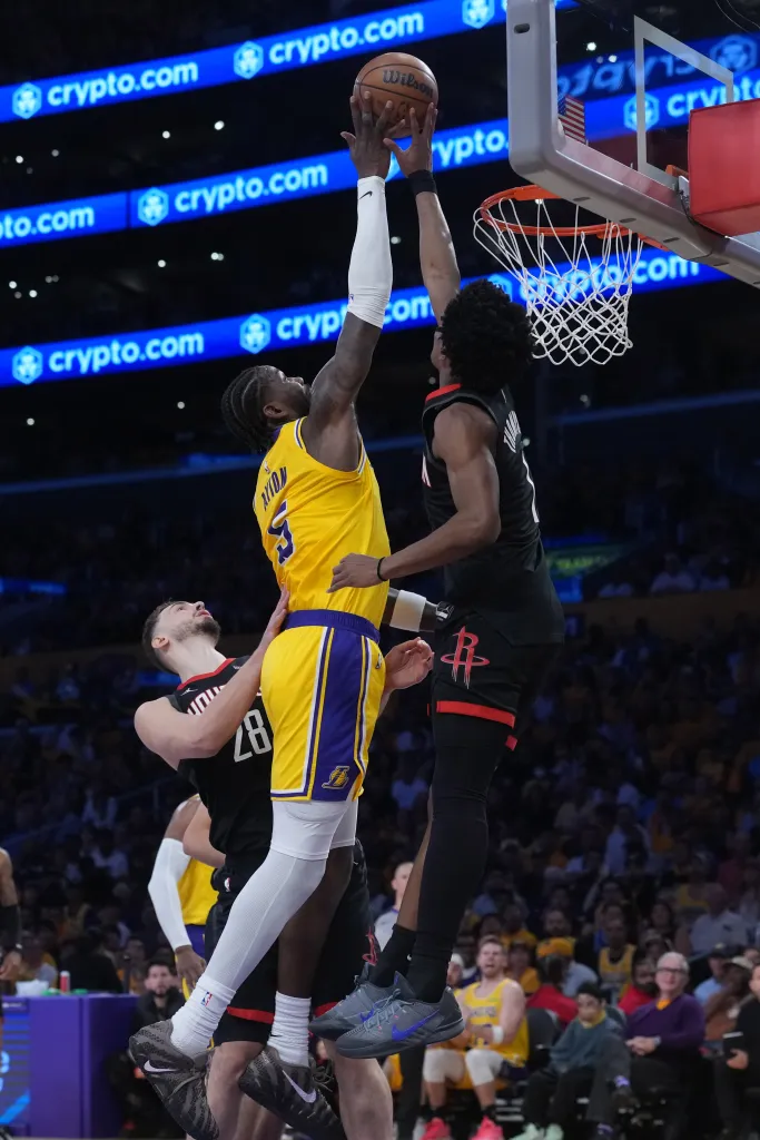 Los Angeles Lakers and Houston Rockets players jumping for a basketball.
