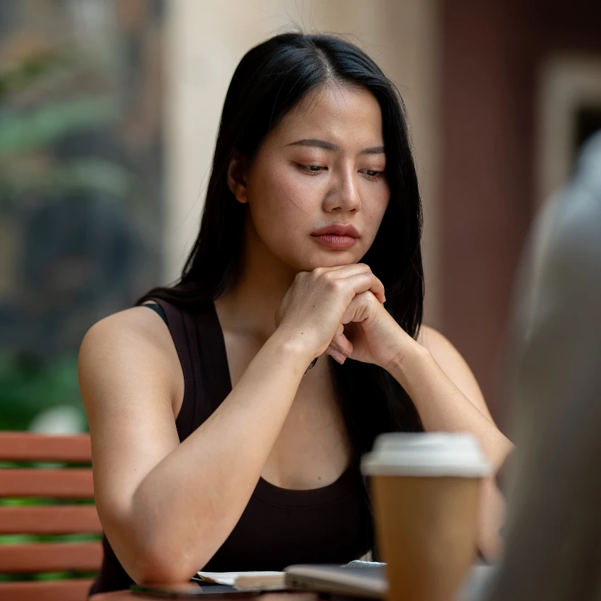 serious woman with cup of coffee on table