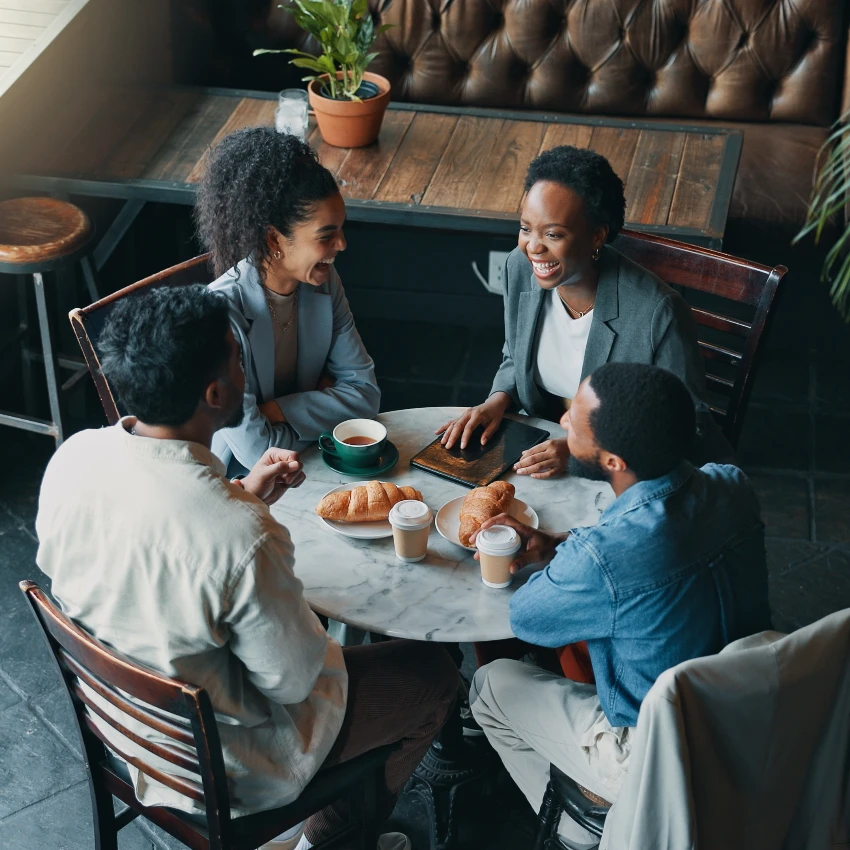 friends sitting around table at restaurant and talking