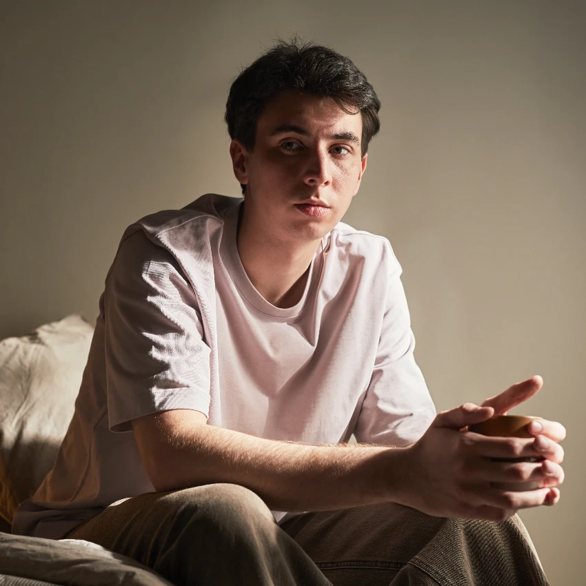 depressed former child prodigy sitting on bed